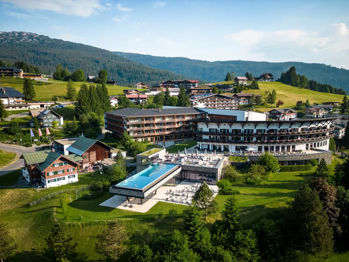 A-ROSA Ifen Hotel Kleinwalsertal Das A-ROSA Ifen Hotel Kleinwalsertal mit Pool inmitten einer malerischen Berglandschaft.