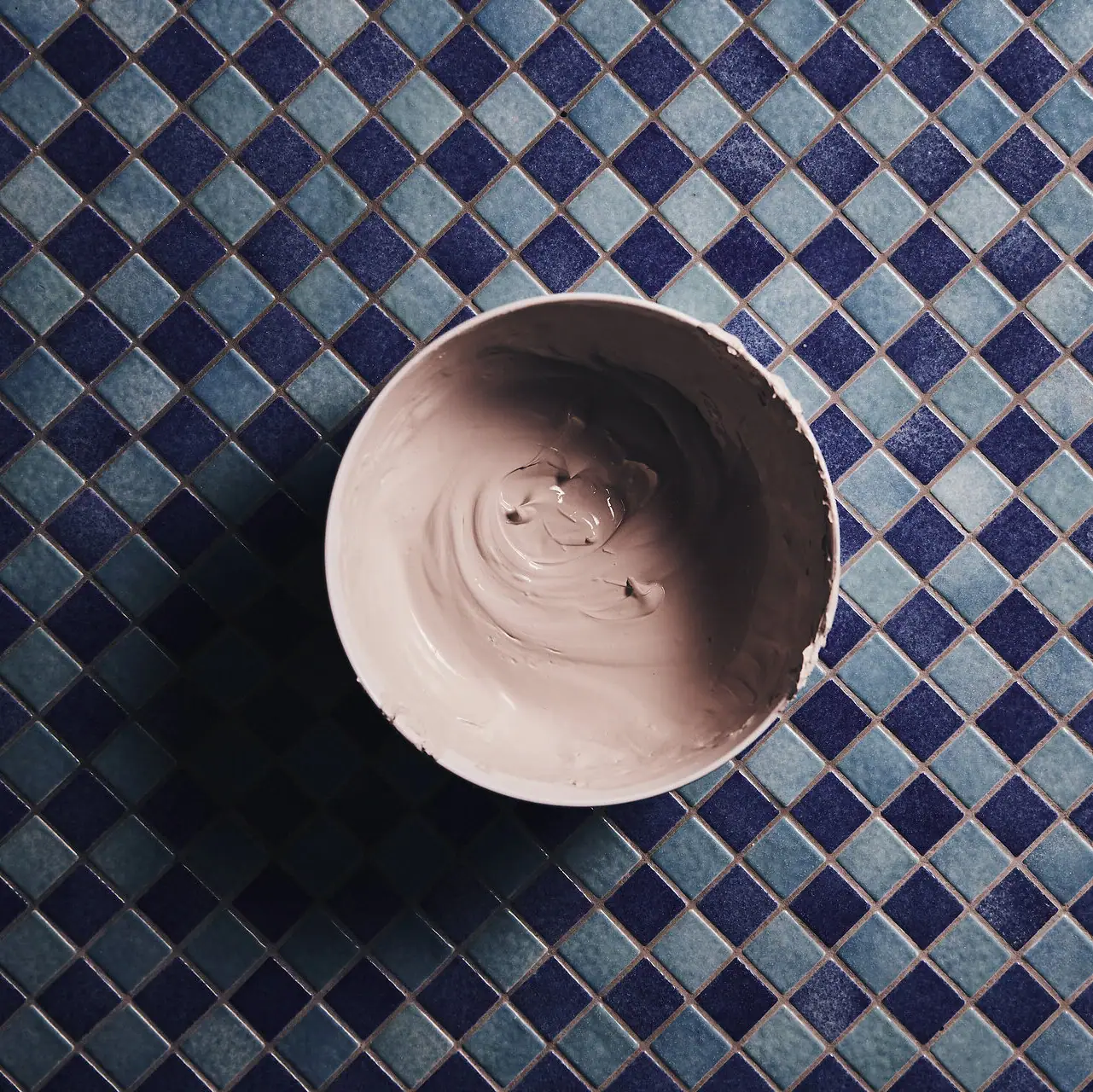 SPA Treatments Bowl of clay on a tile surface.