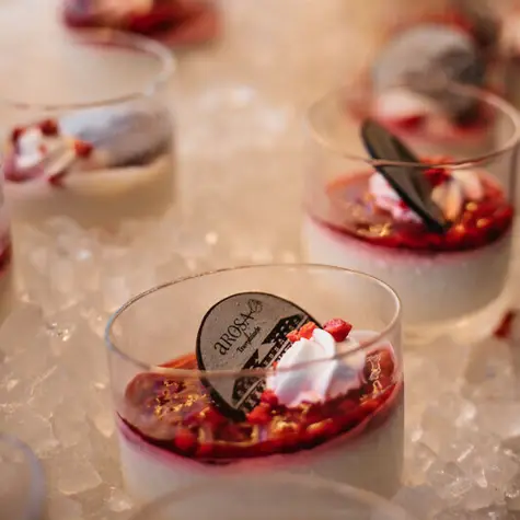 A group of glasses with desserts on ice.