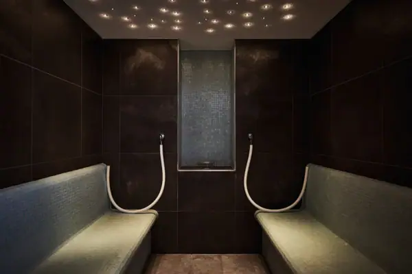 Shower room with tiled walls, benches, and a window.