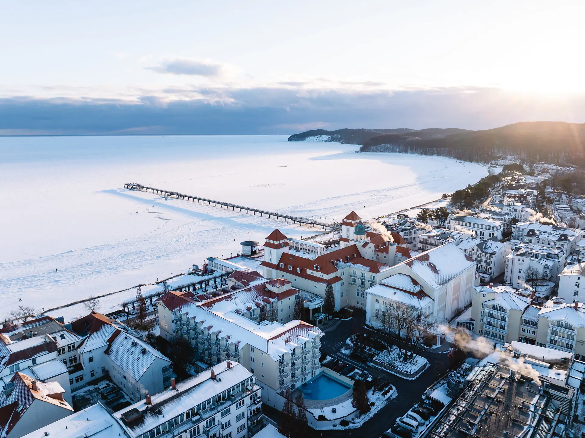 A snow-covered town beside a body of water.