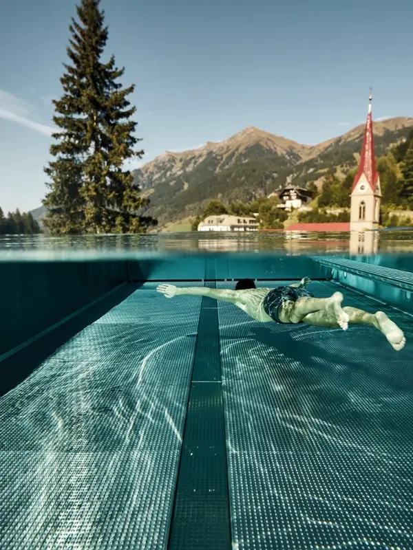 A person swimming in an outdoor pool.