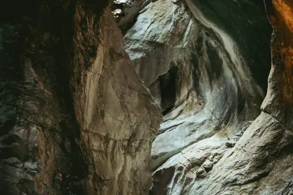 Varone Waterfall A cave with a hole in the wall, surrounded by natural rock formations.