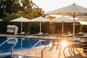 An outdoor pool with parasols and deckchairs.