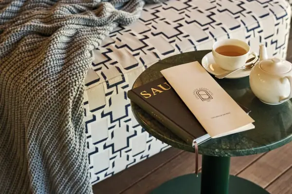 A table with a book and a cup of tea on it.