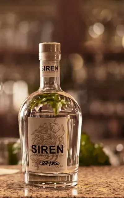 A bottle of "Siren" gin on a bar.