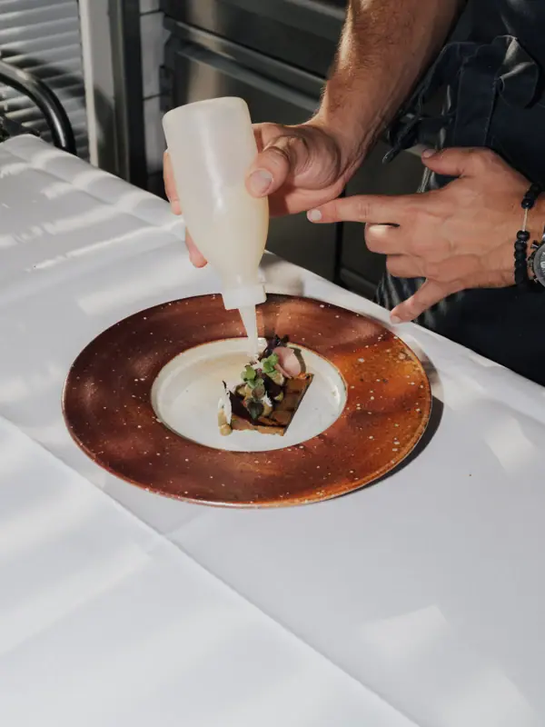 A person pours a liquid onto a plate.
