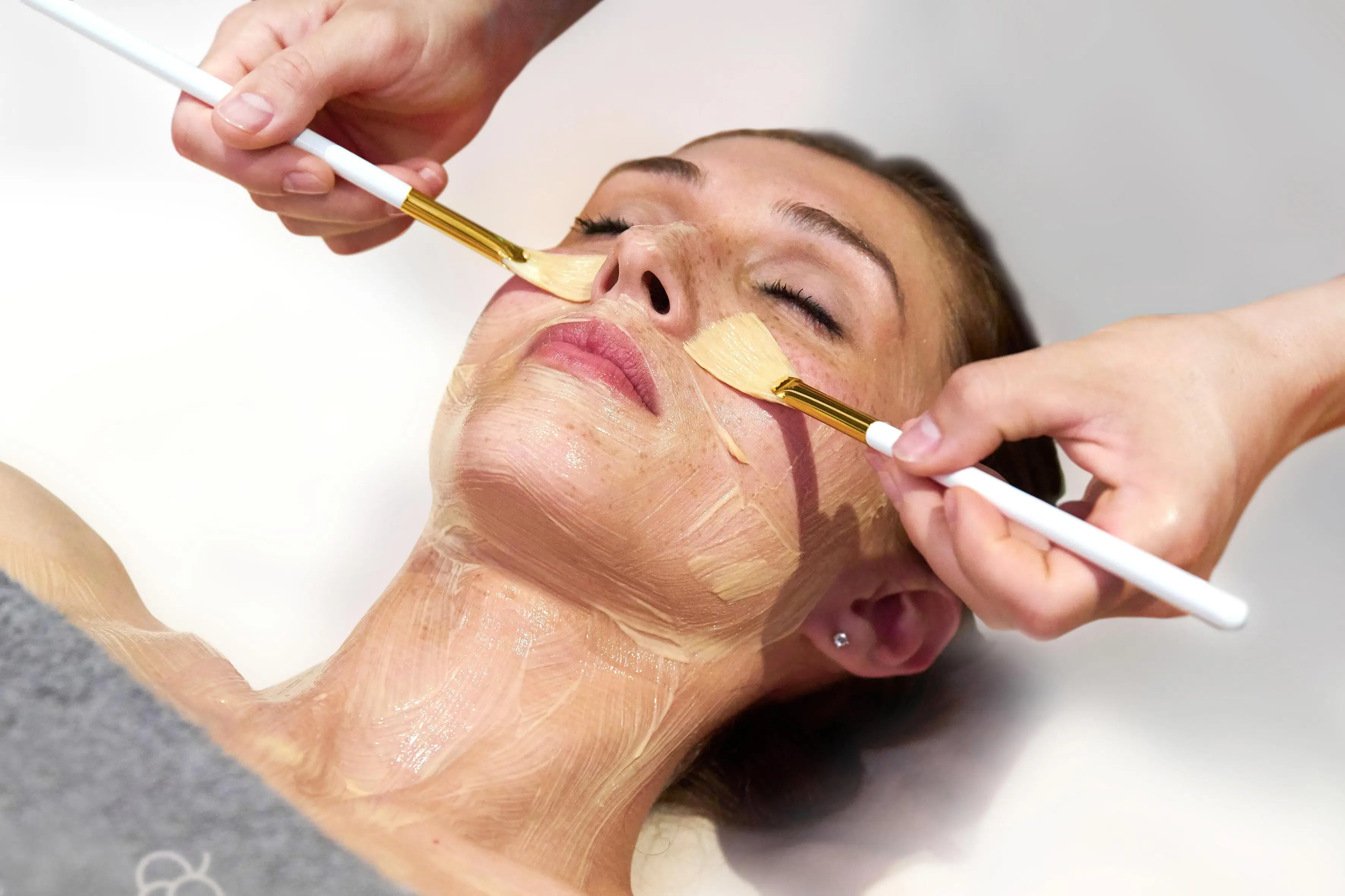 Face Treatment A woman receiving a face mask indoors.