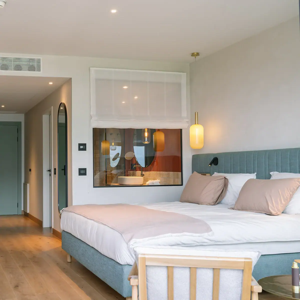 Schlafzimmer mit Bett und Fenster ins Badezimmer.