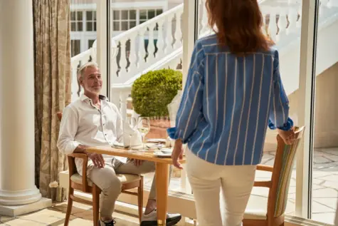 Woman and man standing next to a table.