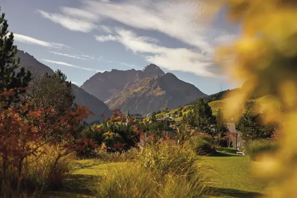 Herbstliche Landschaft mit Berg im Hintergrund, umgeben von Wolken und Gras im Herbst.