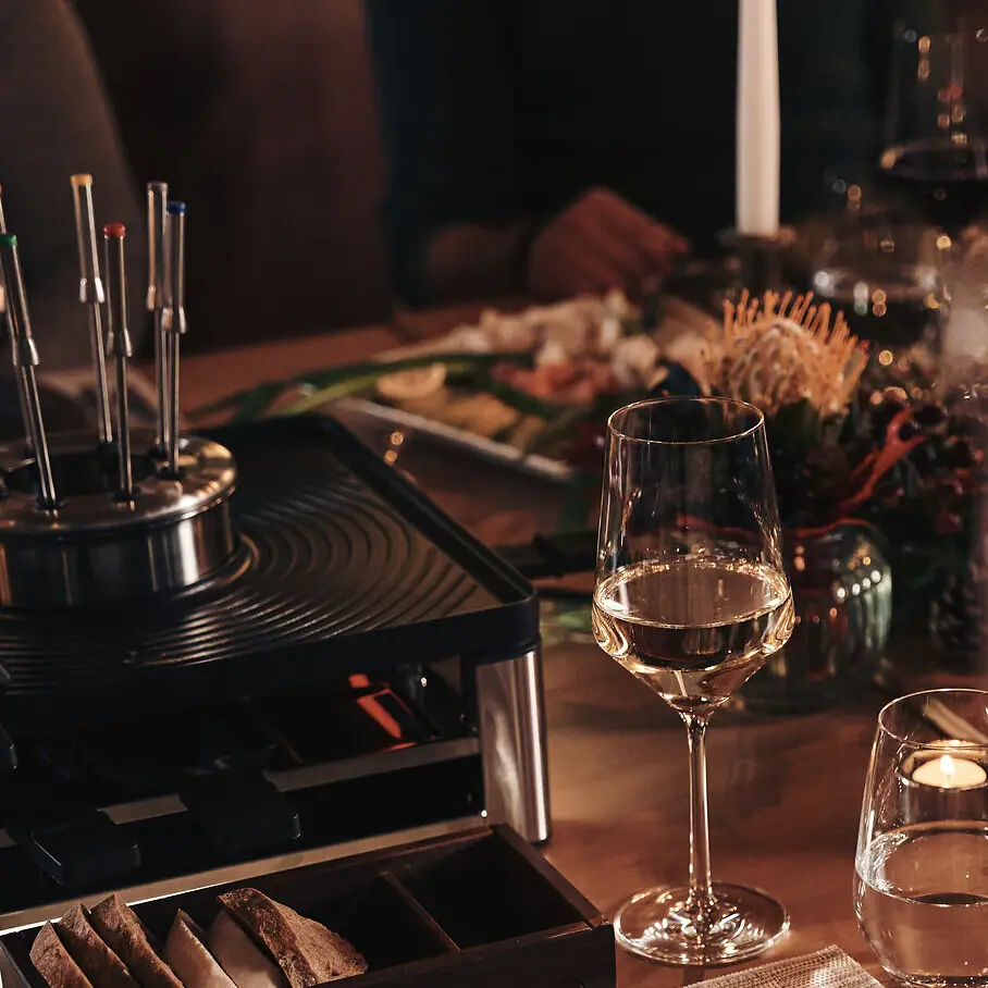 A table with plates and wine glasses.