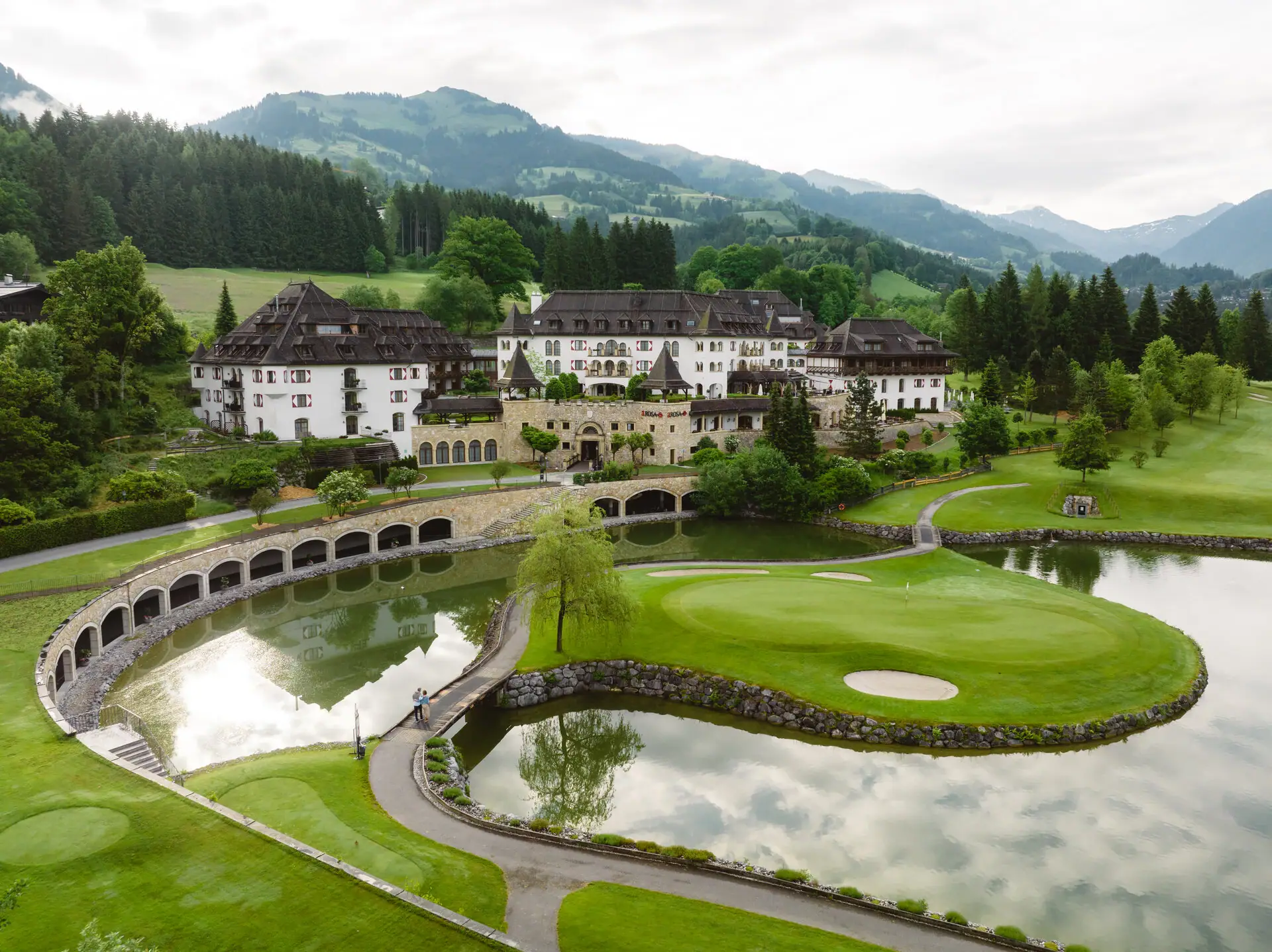 Golfplatz mit großem Gebäude und einem See im Vordergrund