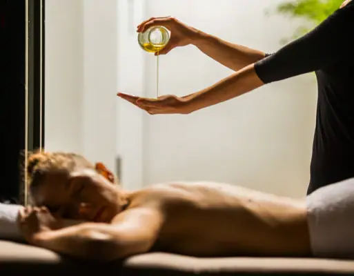 A person pouring oil into another person's hand indoors.