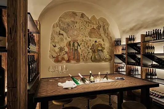 Wine cellar with a table set with wine glasses.