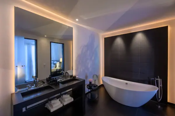 Bathroom with bathtub and washbasin, equipped with modern fittings and a mirror.