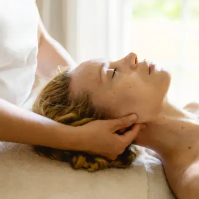 Eine Frau liegt entspannt auf einem Massagetisch.