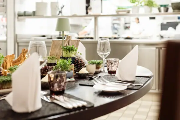 A table with a place setting and a vase.