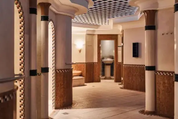 A room with columns and a sink, featuring elegant interior design.