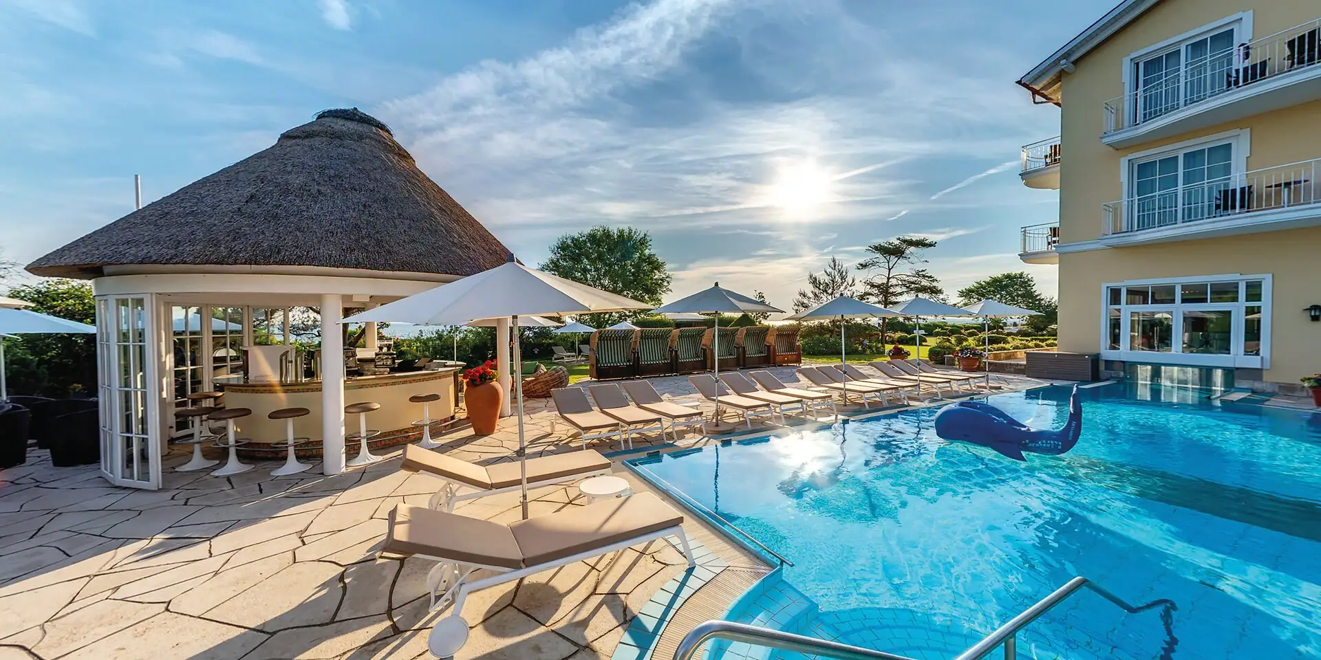 Ein Pool mit Liegestühlen und Sonnenschirmen.