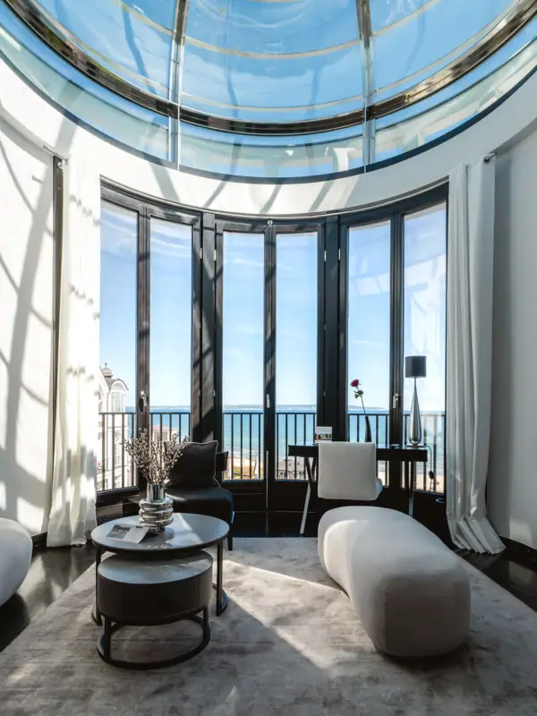 A room with a large window, featuring a large table and chairs.