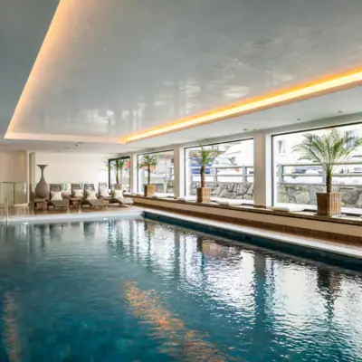 Ein großes Hallenbad mit einem großen Pool und einem großen Fenster.