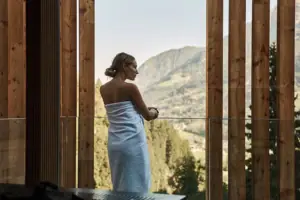 Eine Frau in einem Handtuch steht am Fenster.