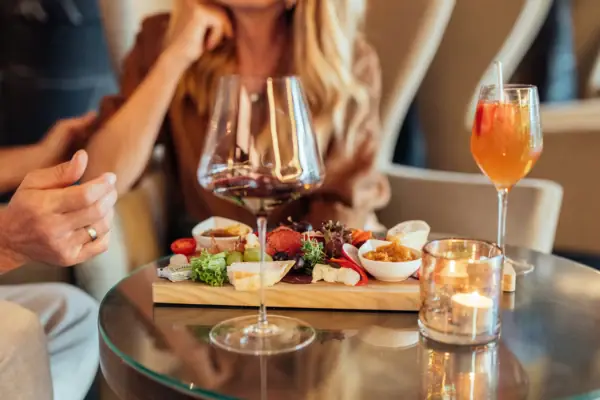 Couple during the meal A table with food and drinks, including wine glasses and tableware.