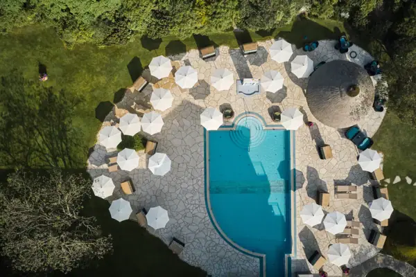 Luftaufnahme eines Pools mit Sonnenschirmen