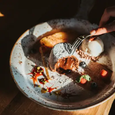 Eine Person isst Dessert mit einer Gabel.