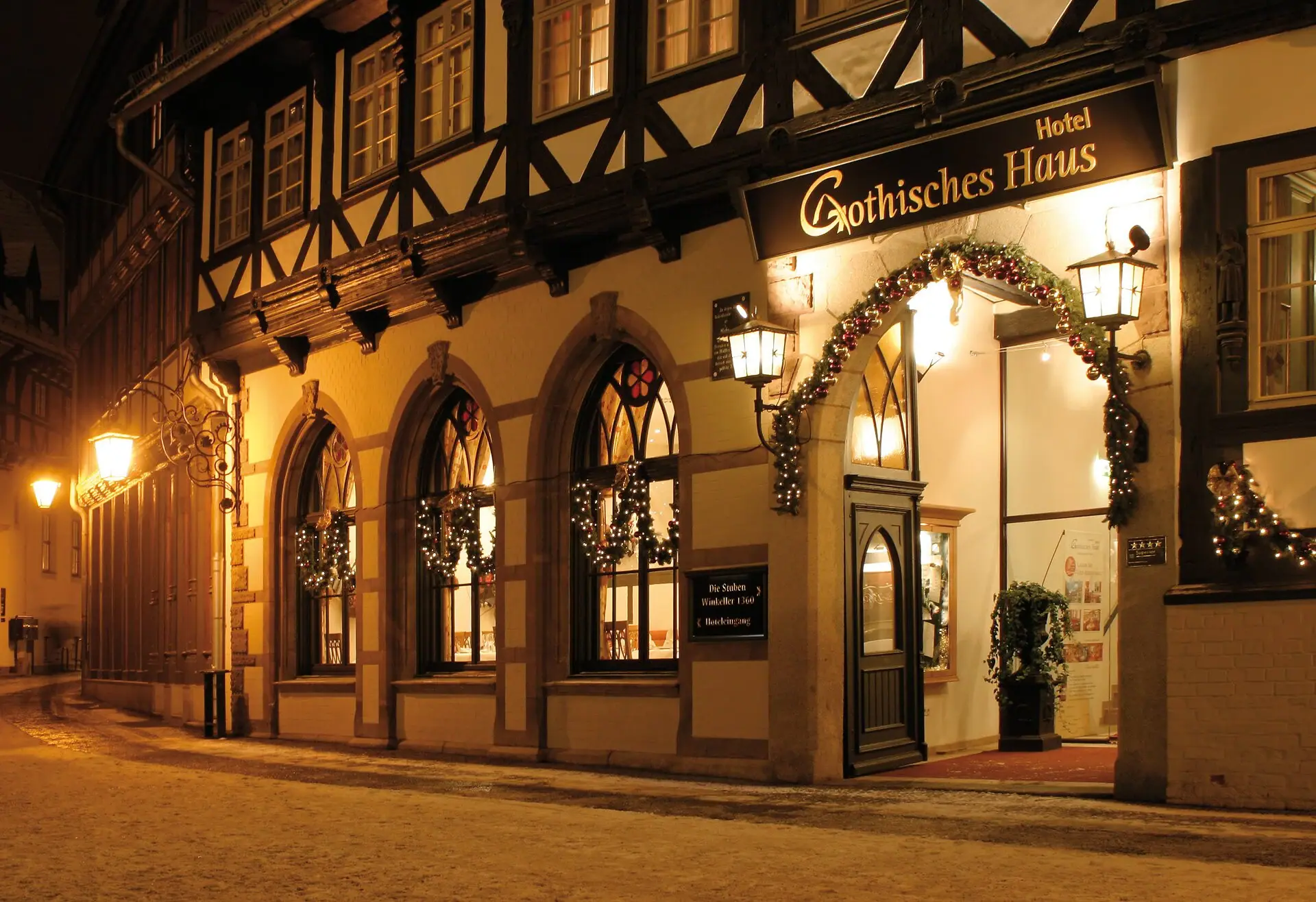 The entrance to the A-ROSA Gothisches Haus at night, decorated for Christmas.