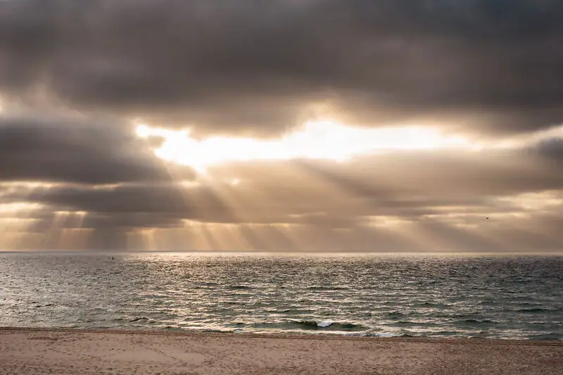 Sonne über dem Meer Sonne scheint durch die Wolken über dem Ozean.