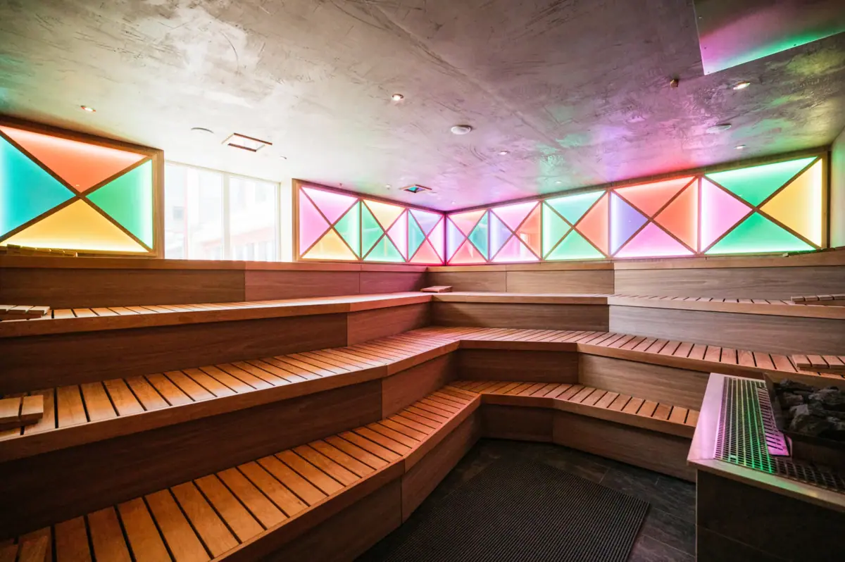 Sauna room with wooden benches and colourful lights