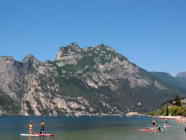 People on stand up paddle boards on a lake surrounded by mountains.