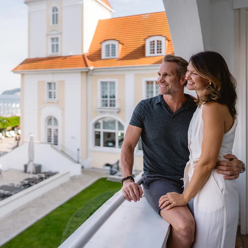 A man and a woman are sitting on a balcony.