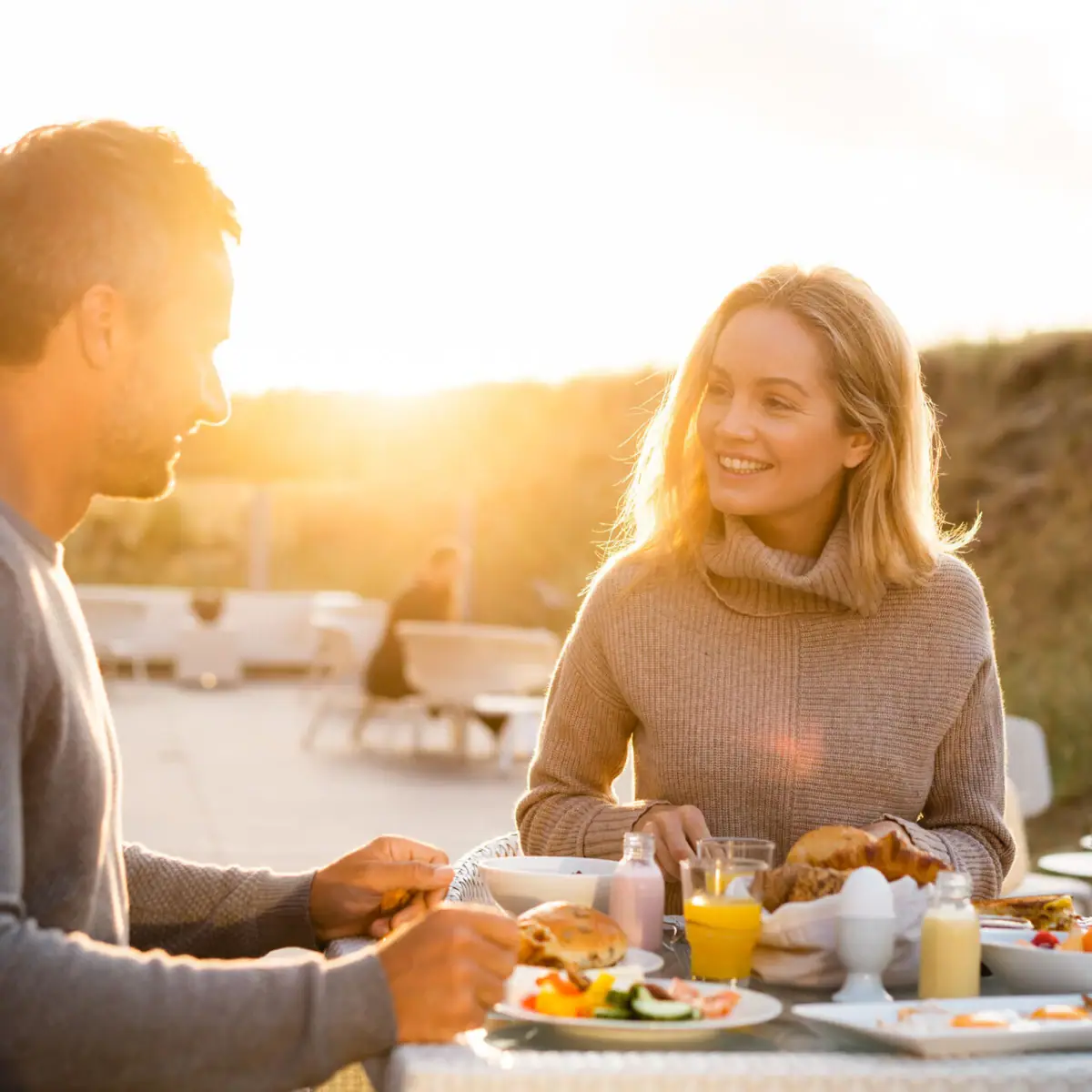 Ein Mann und eine Frau sitzen an einem Tisch mit Essen.