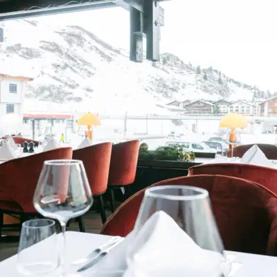 A restaurant with laid tables and wine glasses.