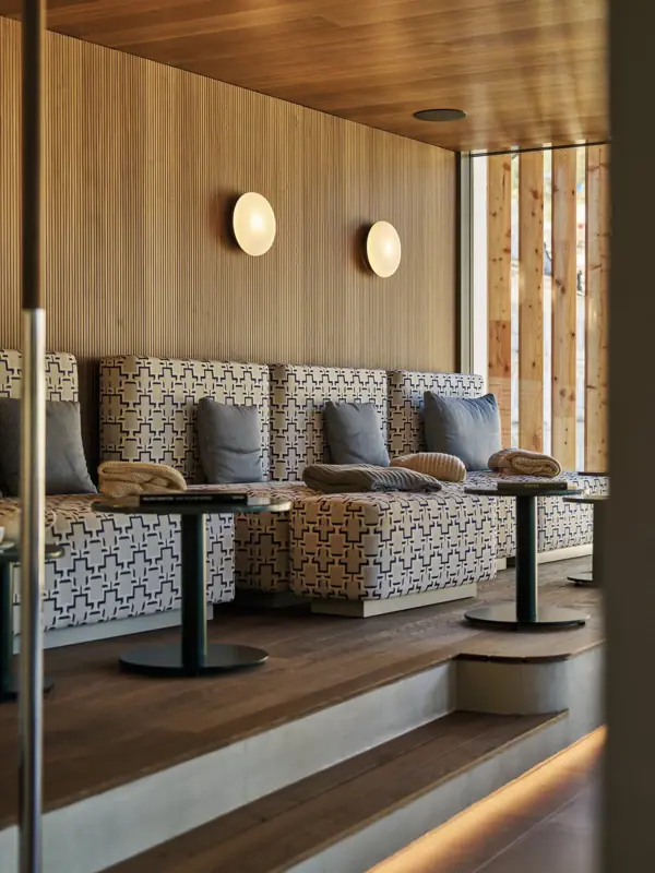 A sofa with cushions and a table against a wall