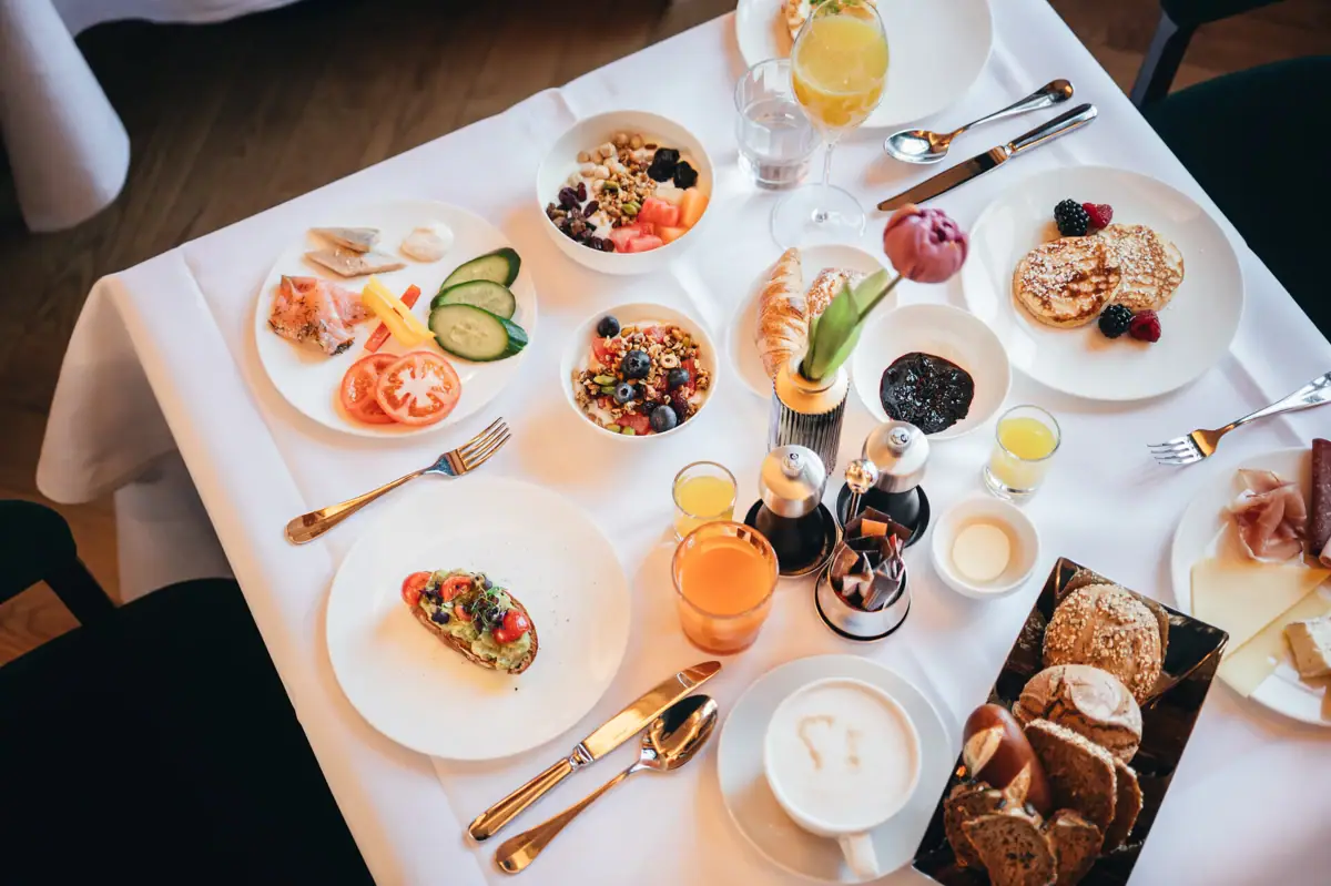 A table with plates of diverse culinary dishes and drinks.
