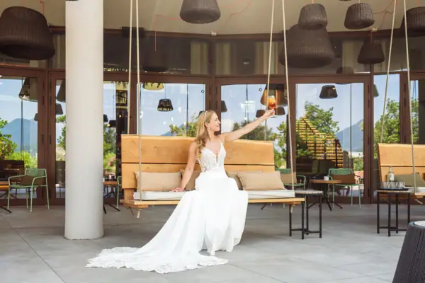 Mediterranes Flair auf Terrasse und im Garten Braut sitzt auf einer Schaukelbank auf der Terrasse mit Blick in den Garten.