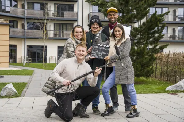 A group of people pose smiling for a photo outdoors.