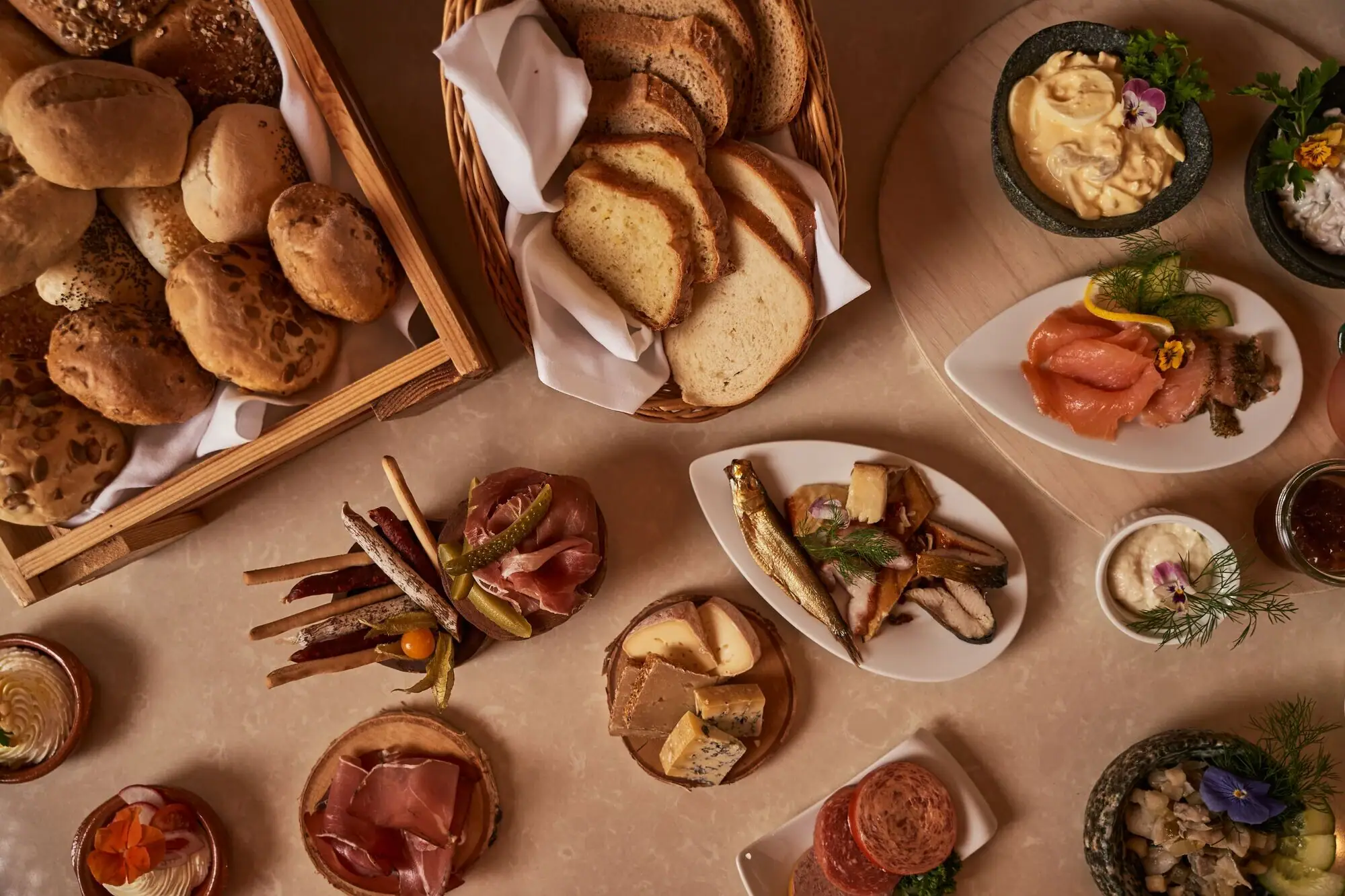 A table with a variety of food items, including a platter of delicacies and snacks.
