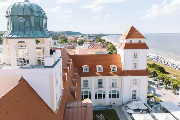 Ein Gebäude mit Glockenturm und Strand im Vordergrund.