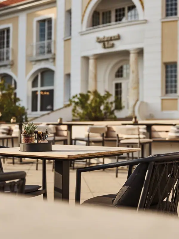 Outdoor table and chairs in front of a building with windows.