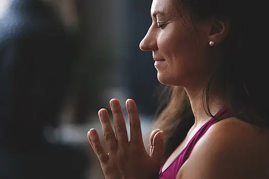 A woman with her hands clasped.