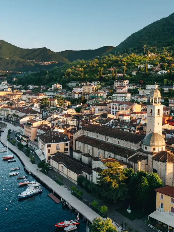 Stadt am Wasser mit Gebäuden und Bergen im Hintergrund.