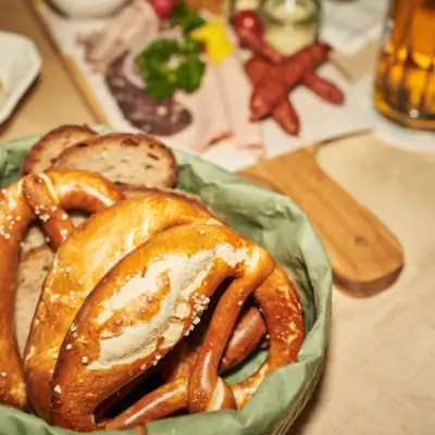 A bowl of pretzels and bread on a table.
