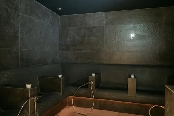 Dampfige Sauna mit dunklen Flächen für Peeling-Rituale im A-ROSA Gardasee.