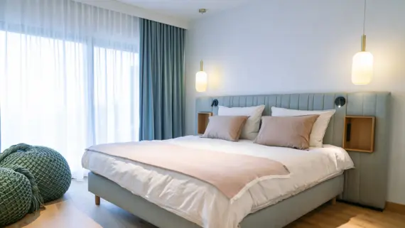 A bed in a comfortably furnished hotel room.