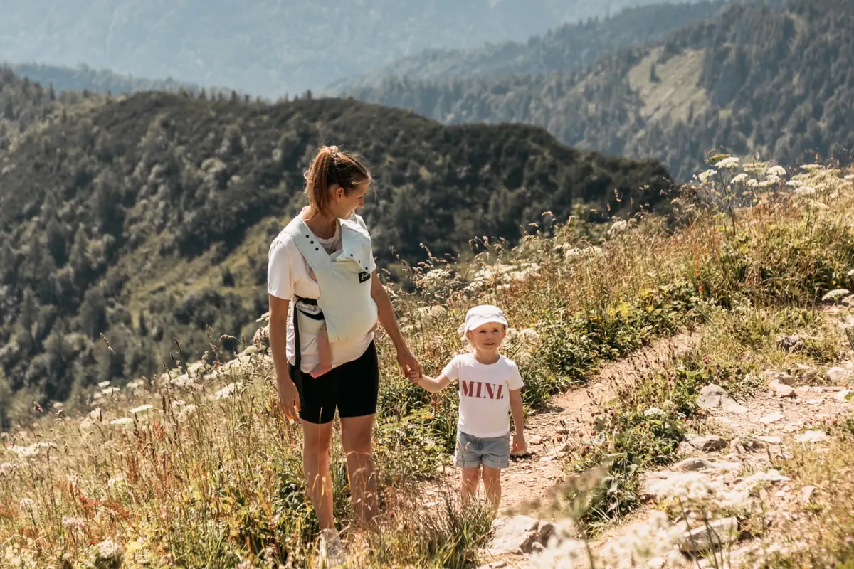 A woman and a child hiking on a mountain.